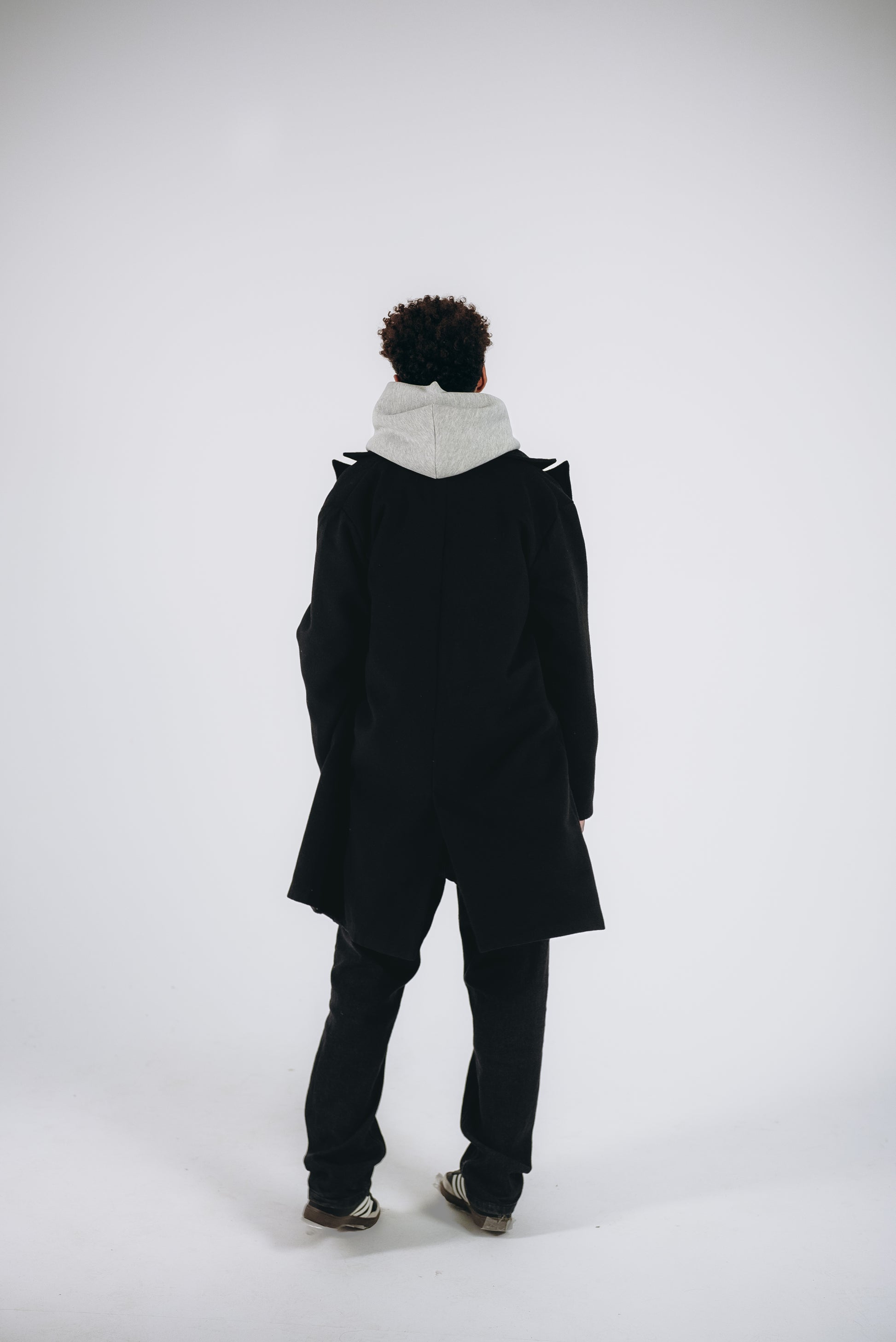 a model has a Back shoot for black coat with hoodie
