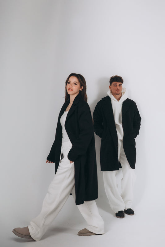Two models are wearing oversized black coat layering with white set of hoodies and sweatpants