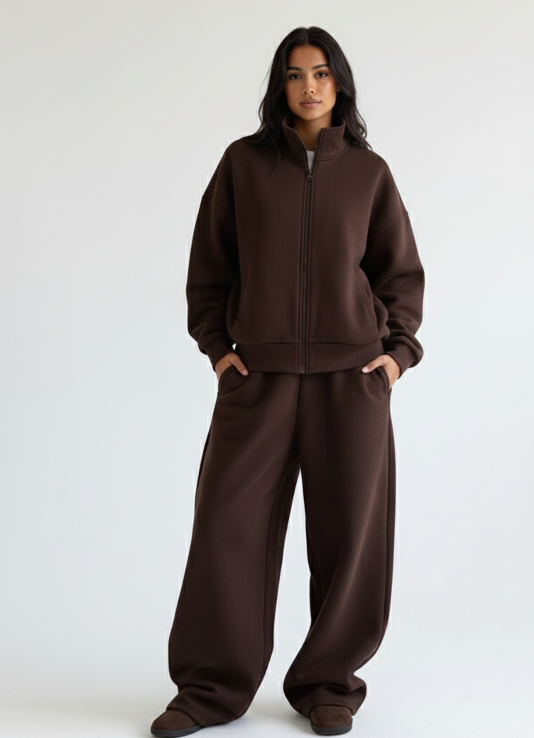 Woman wearing Riot Leveret Club a brown tracksuit against a white background